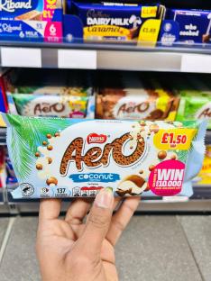 Hand holding a Nestle Aero Coconut chocolate bar.