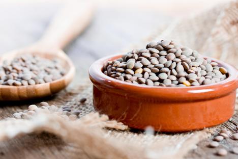 Brown lentils in a bowl and spoon.