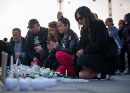 A woman lights candles at a vigil.