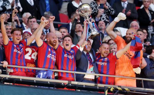 Aldershot Town players celebrating a trophy win.