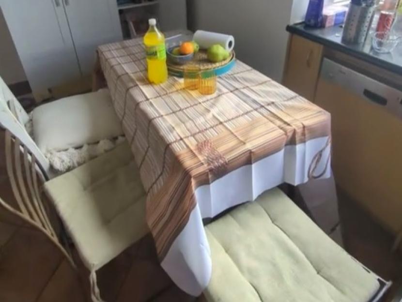 A kitchen table covered with a printed sheet that looks like a bamboo blind.