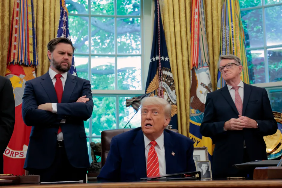 Donald Trump speaking at a press conference with two other men.