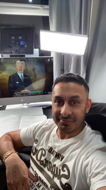 Self-made millionaire taking a selfie at his desk.