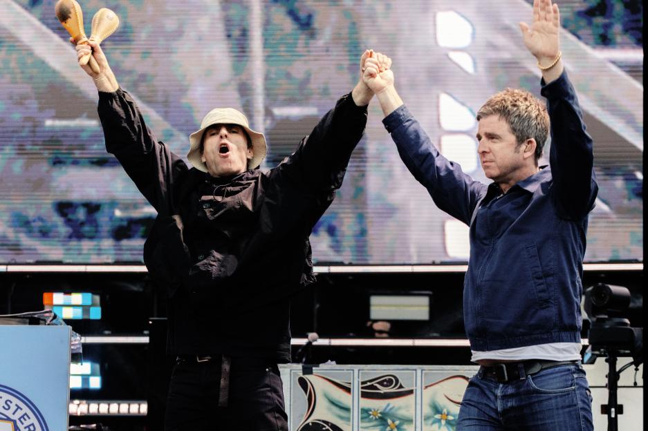 Liam and Noel Gallagher of Oasis performing on stage.