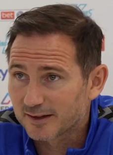 Frank Lampard throwing a dart at a dartboard.
