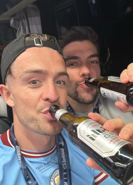 Jack Grealish and Stefan Ortega Jr. drinking beer while celebrating.