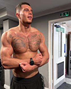 Muscular man with chest tattoos.