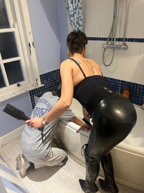 Zara the dominatrix and a man in a t-shirt in a bathroom.