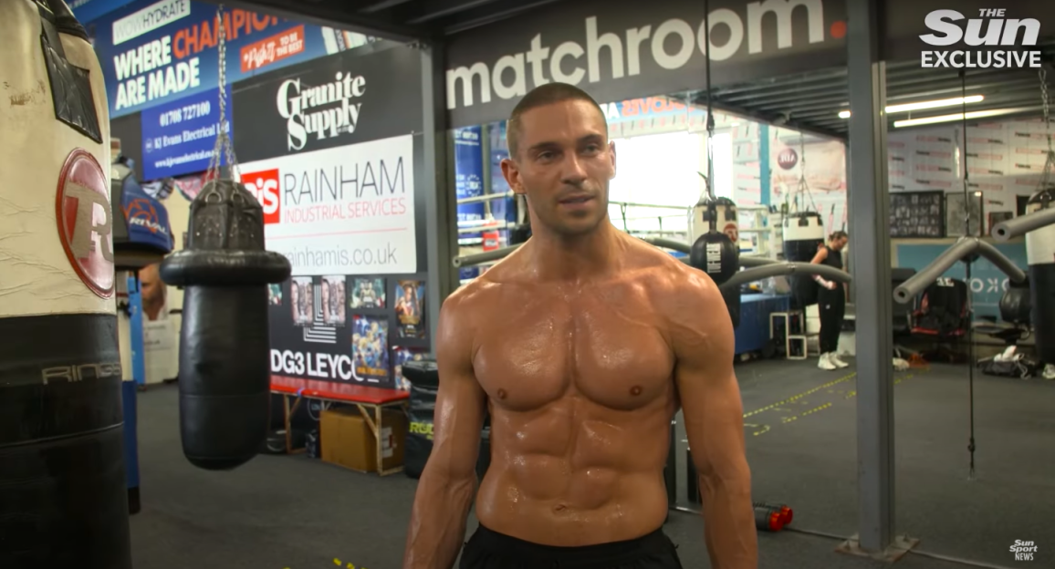 Shirtless man in boxing gym.