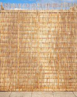 Privacy fence made of woven reeds.