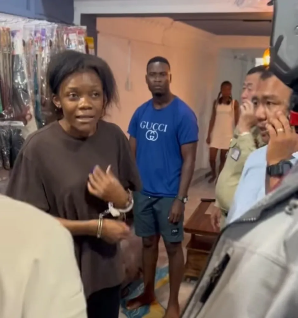 Woman in handcuffs with onlookers.