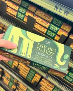 Hand holding a box of M&S The Big Daddy Pistachio chunky chocolate bar.