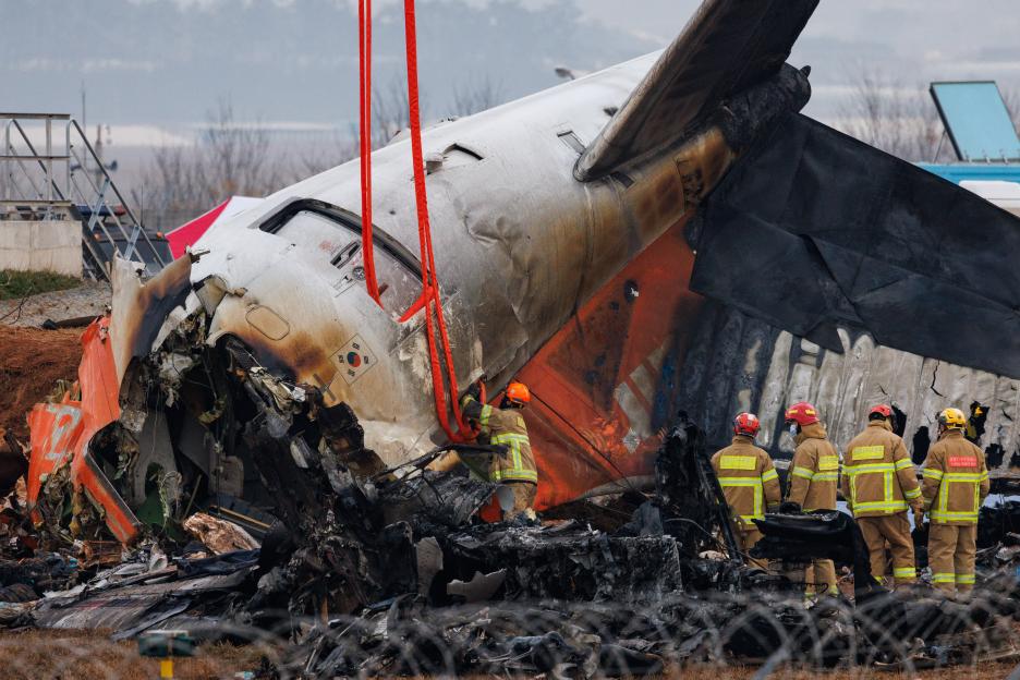 Firefighters inspect the wreckage of Jeju Air Co. Flight 2216 at Muan International Airport.