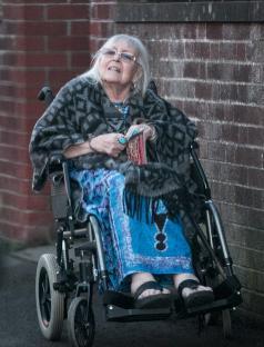 a woman in a wheelchair is wearing a blue dress