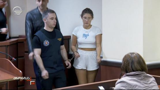 A handcuffed woman in court.