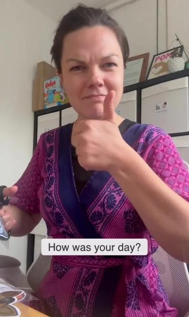 Woman giving thumbs up, saying "How was your day?"