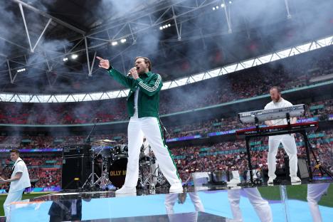 Olly Murs performing on stage at a stadium.