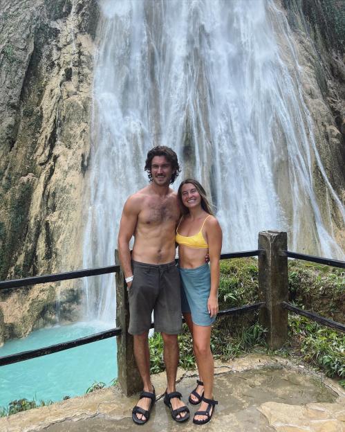 Couple posing in front of a waterfall.