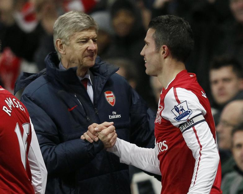 Arsenal's manager Arsène Wenger shaking hands with Robin Van Persie, who is wearing a captain's armband.