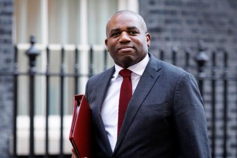 Portrait of a man in a suit holding a red folder.