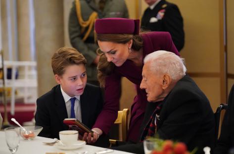 Prince George and Princess Catherine with a World War II veteran at a Buckingham Palace tea party.