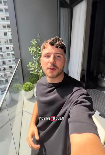 A man on a balcony with the text "MOVING TO DUBAI" overlaid.