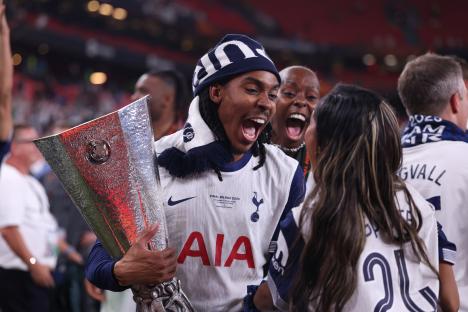 Djed Spence of Tottenham Hotspur celebrates with the UEFA Europa League trophy and his family.