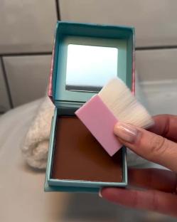 Bronzer compact with brush.