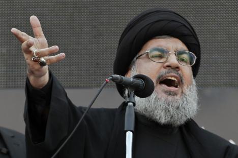 Hezbollah leader Sheik Hassan Nasrallah speaking at a microphone.