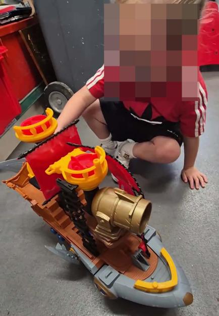 Child playing with Imaginext pirate ship toy.
