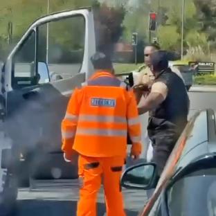 Road rage incident: a man in an orange jacket is being attacked by another man.