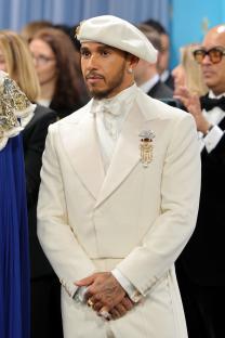 Lewis Hamilton at the Met Gala in a white suit and beret.