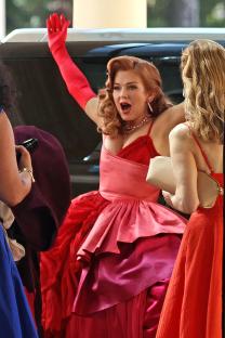 Isla Fisher in a red dress on the set of *Spa Weekend*.