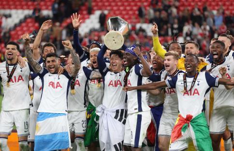 Tottenham Hotspur players celebrating a victory with the UEFA Europa League trophy.