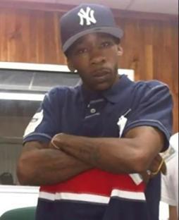 Man wearing a New York Yankees baseball cap and a navy polo shirt with red and white stripes.