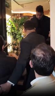 Ronaldo being helped out of a restaurant.