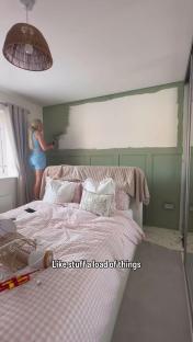 Woman painting bedroom wall sage green.