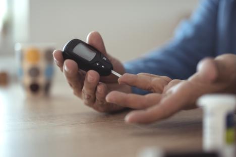 Person using a glucometer to check their blood sugar.