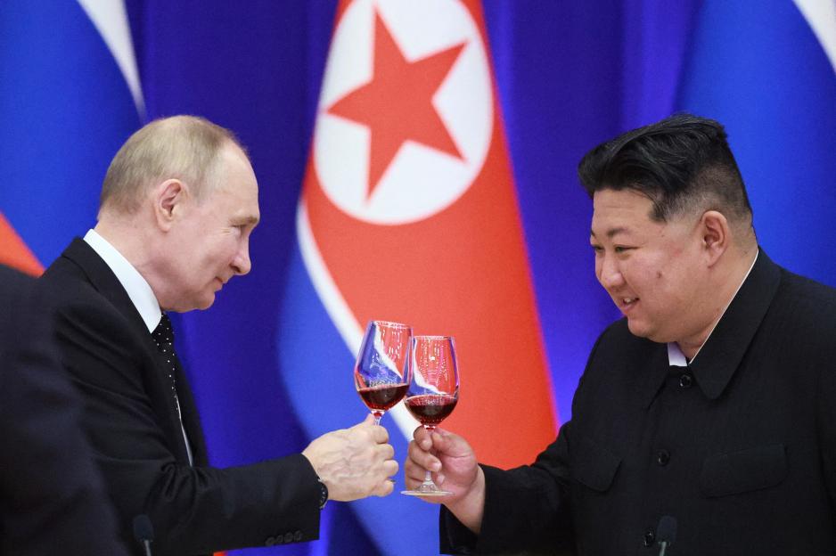 Putin and Kim Jong Un toasting with wine.