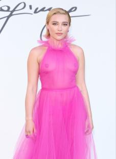 Florence Pugh in a sheer pink dress at a fashion show.