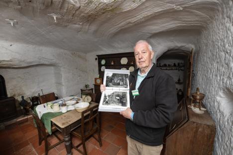 A National Trust volunteer giving a tour of a rock house, playing recordings of his family.