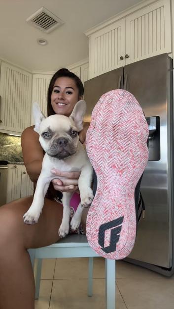 Woman comparing her foot to her dog's paw.