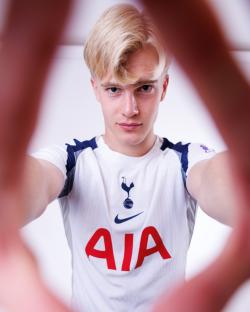 A young man in a Tottenham Hotspur jersey takes a selfie.