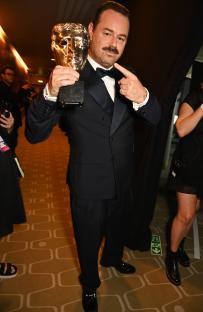 Danny Dyer holding a BAFTA award.