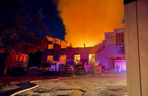 Firefighters at the scene of a building fire at night.