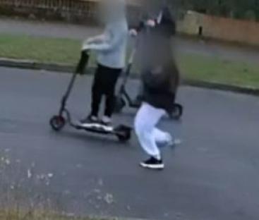 CCTV image of two people on e-scooters and a person running.