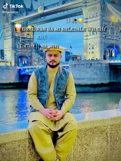 Usama sits in front of the Tower Bridge at night with text overlay from TikTok.