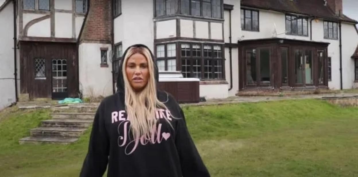 Katie Price standing outside her run-down Mucky Mansion.
