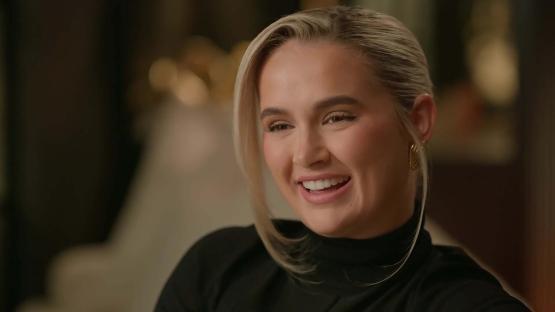 Molly-Mae Hague smiling in a black turtleneck.