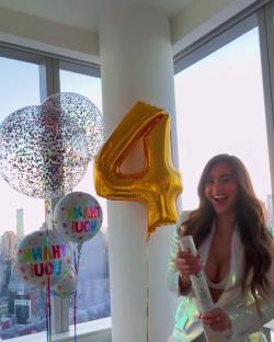 Woman celebrating with balloons and a confetti popper.